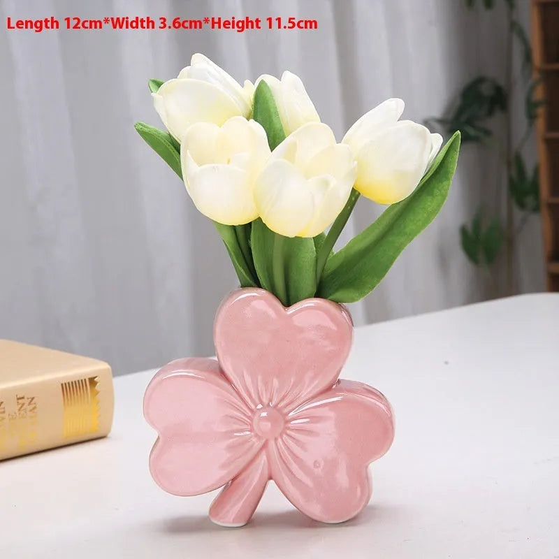 Square white porcelain clover ceramic vase on a desk, shown in light green colour.