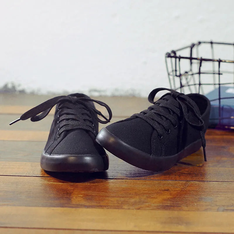 All black women's flat canvas lace-up shoes with a rubber sole