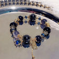Women's bracelet with snowflake pendant and bow charm in galaxy colour