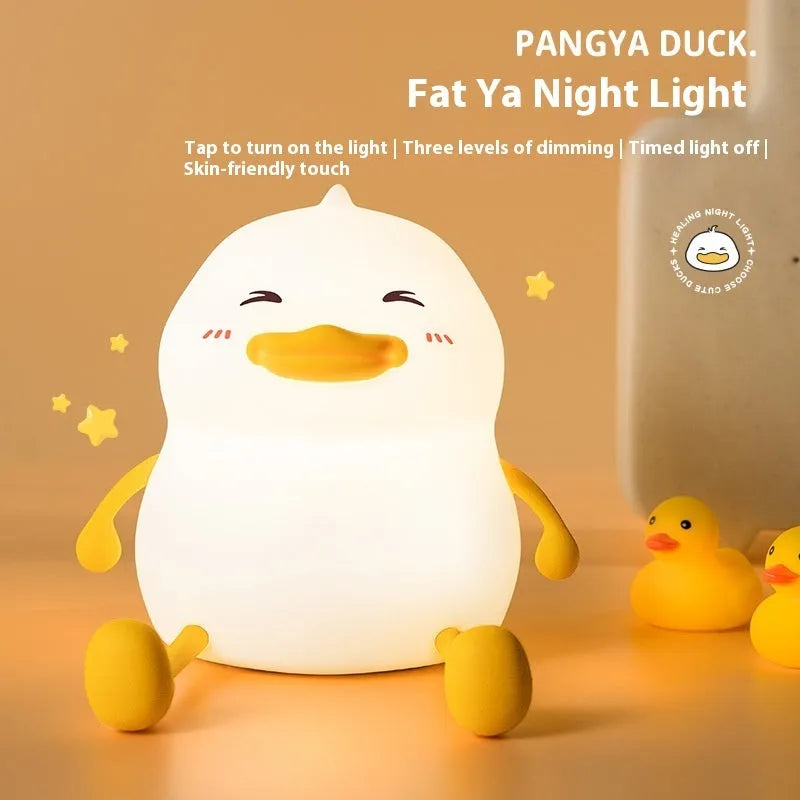 Chubby white USB rechargeable LED night light on a desktop, showing its compact size and soft glow.