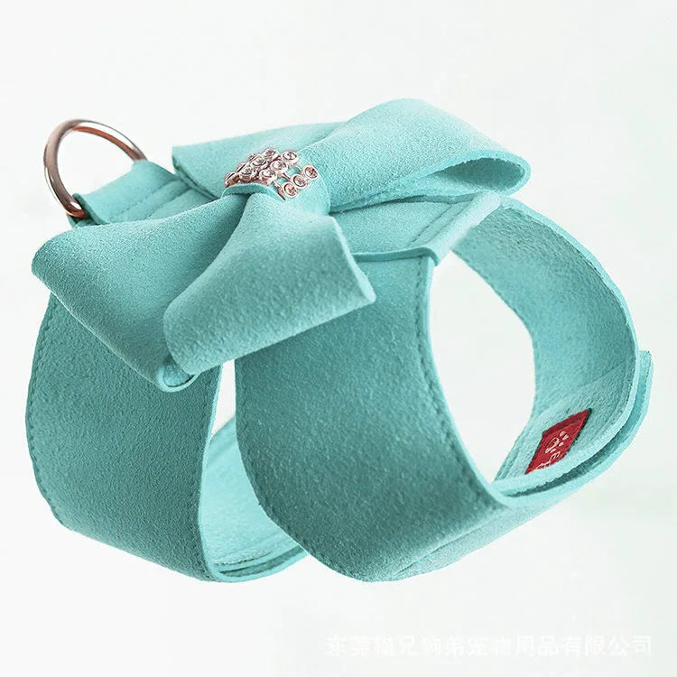 Pink microfiber puppy chest strap with a bowknot, showing the D-ring leash clip.