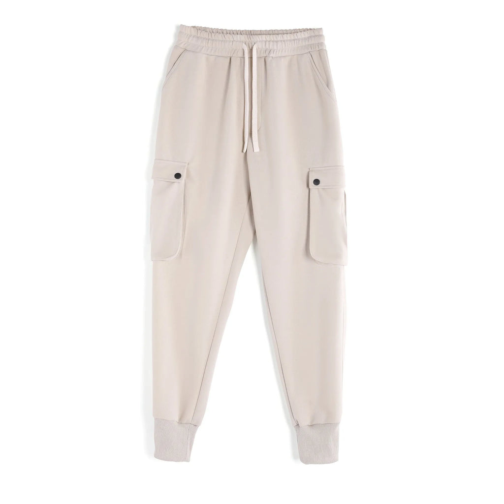Men's loose-fit cotton sports trousers in apricot colour with ankle ties and multiple pockets, laid flat.