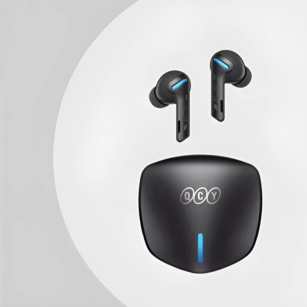Grey QCY BH21G1A wireless Bluetooth gaming earbuds with their compact charging case on a table.