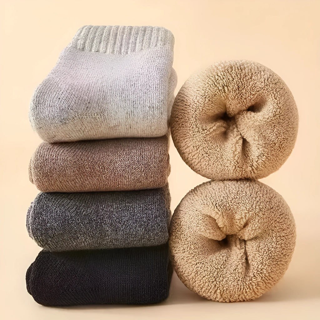 Pair of thick khaki merino wool socks with a ribbed cuff and reinforced heel and toe, shown flat.