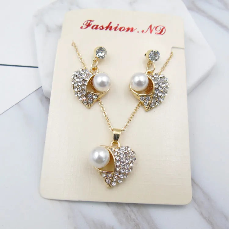 Gold heart pearl jewellery set with alloy necklace and earrings on display