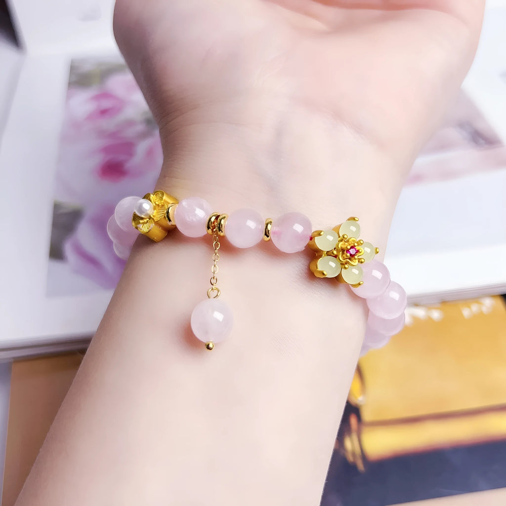 Close-up of a handmade pink crystal peach blossom bracelet on a wrist, showing adjustable closure.