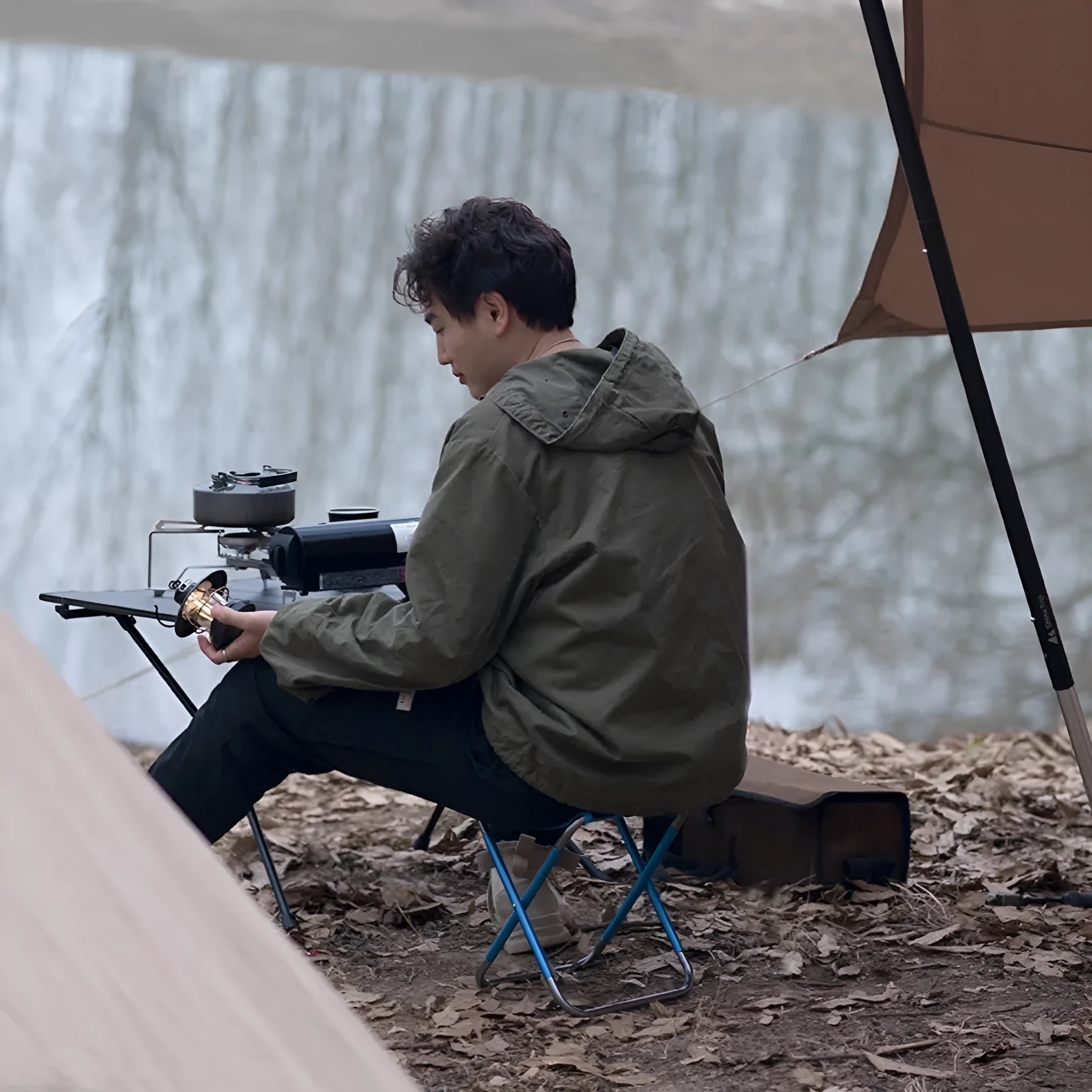 Black folding camping stool with an aluminium alloy frame, shown in a folded and unfolded state.