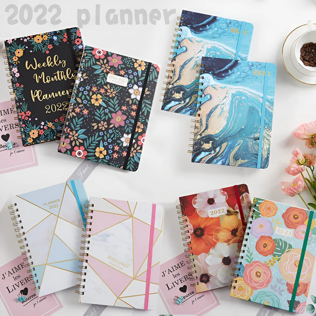 A5 spiral notebook with floral cover design, open to show lined pages.