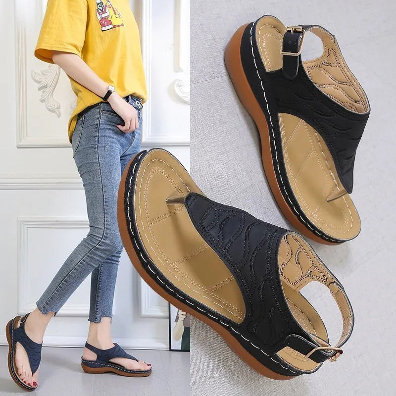 Women's wedge heel flip flop sandals with an adjustable back strap in solid black.
