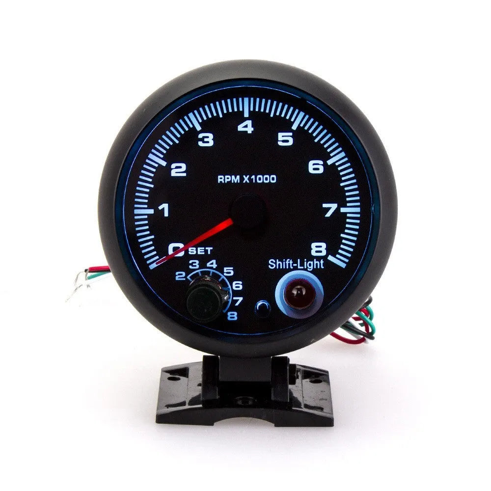 Black automotive tachometer with blue light pointer dial for measuring engine RPM.