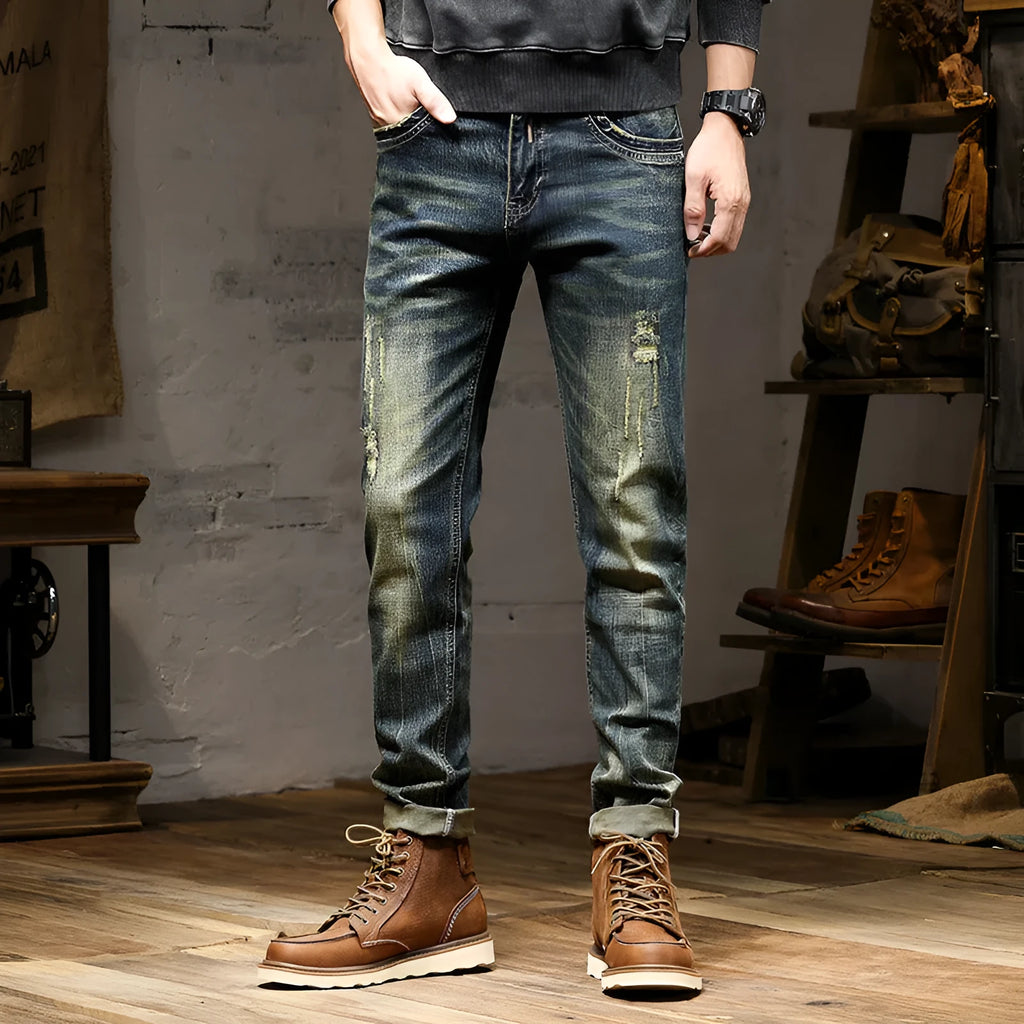 Men's skinny fit jeans in a retro blue wash with a zip fly, shown laid flat.