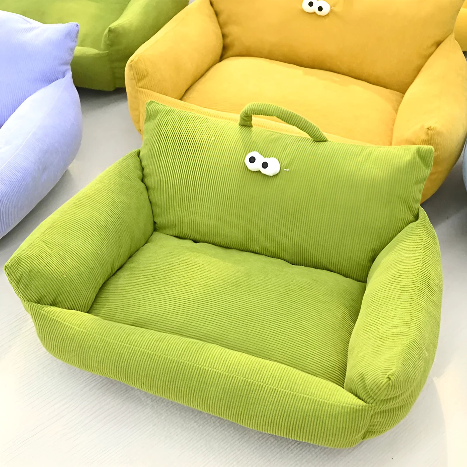 Cartoon big eye pet bed cushion for small dogs and cats in blue, shown with removable sticky eyes.