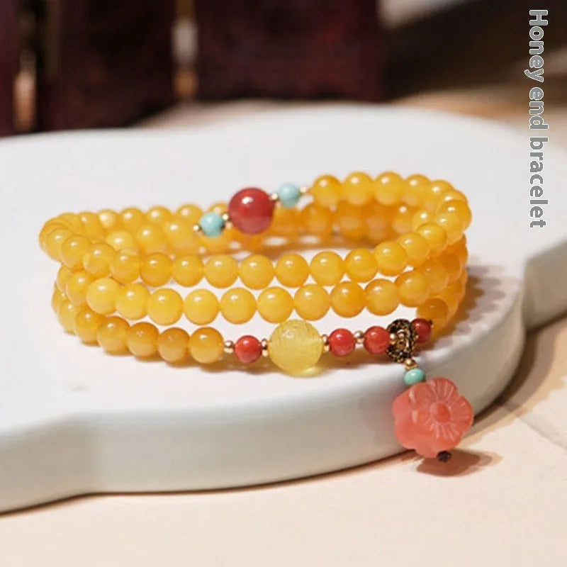 Yellow amber chicken grease beeswax bracelet with 5mm beads and Zodiac modelling on a wrist.