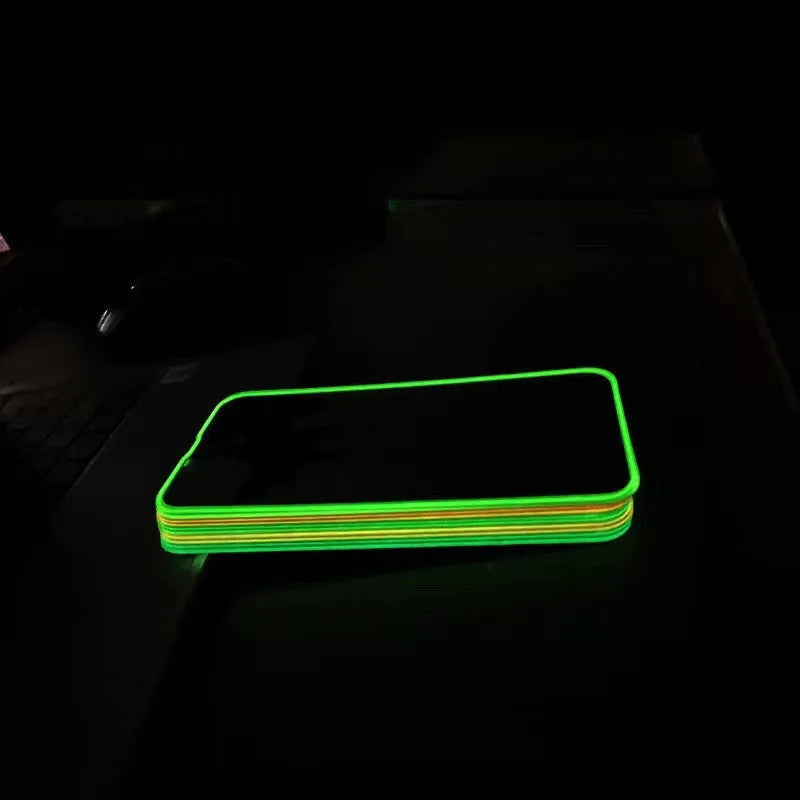 Fluorescent tempered glass screen protector glowing on an iPhone 13, showing pink luminous edge and precise camera cutout.