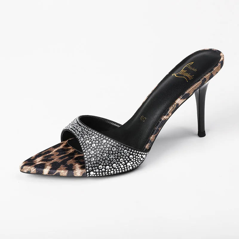Black women's sandals with pointed stiletto heel, rhinestone details, and oversleeves.