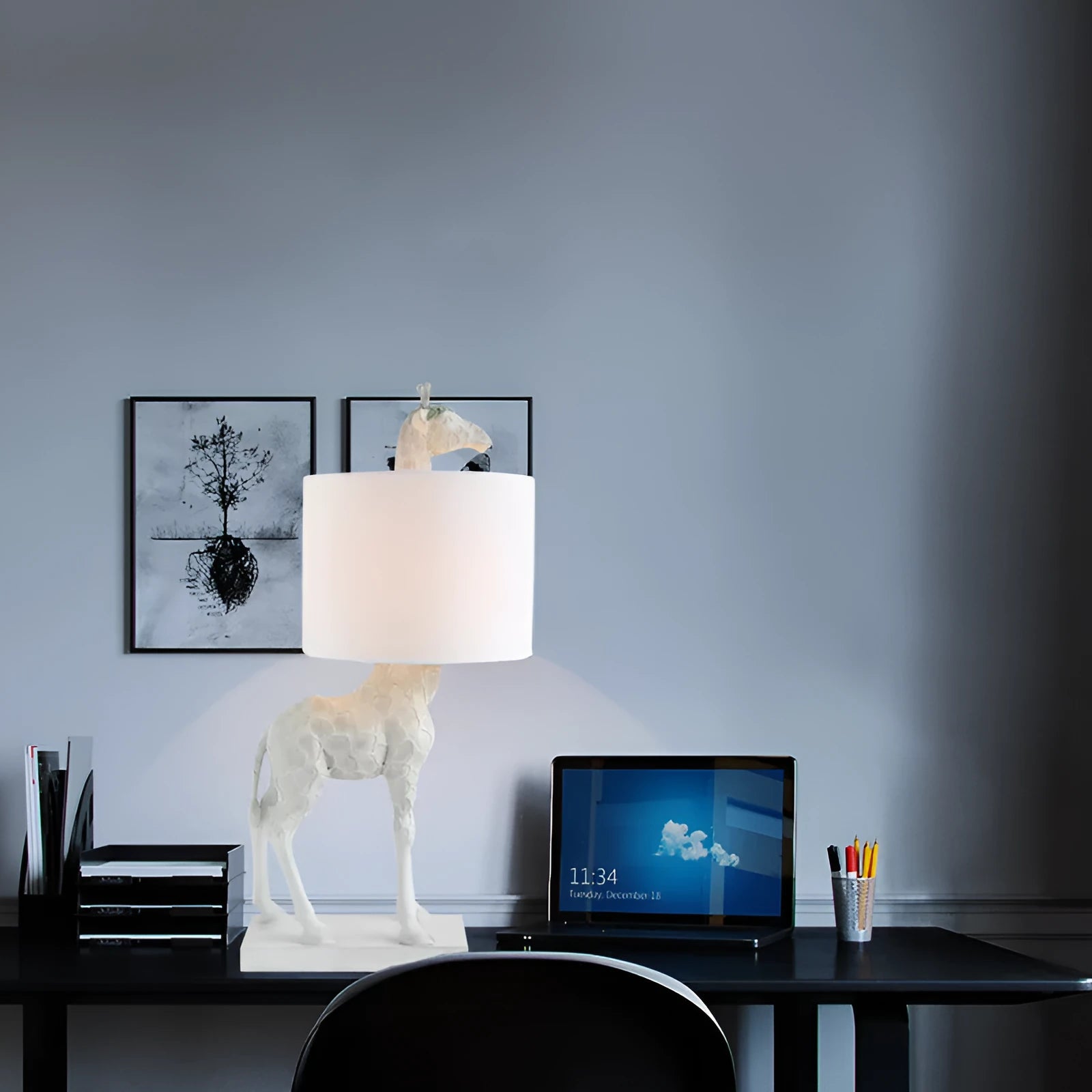 White or gold giraffe-shaped table lamp with cloth shade on a bedside table.