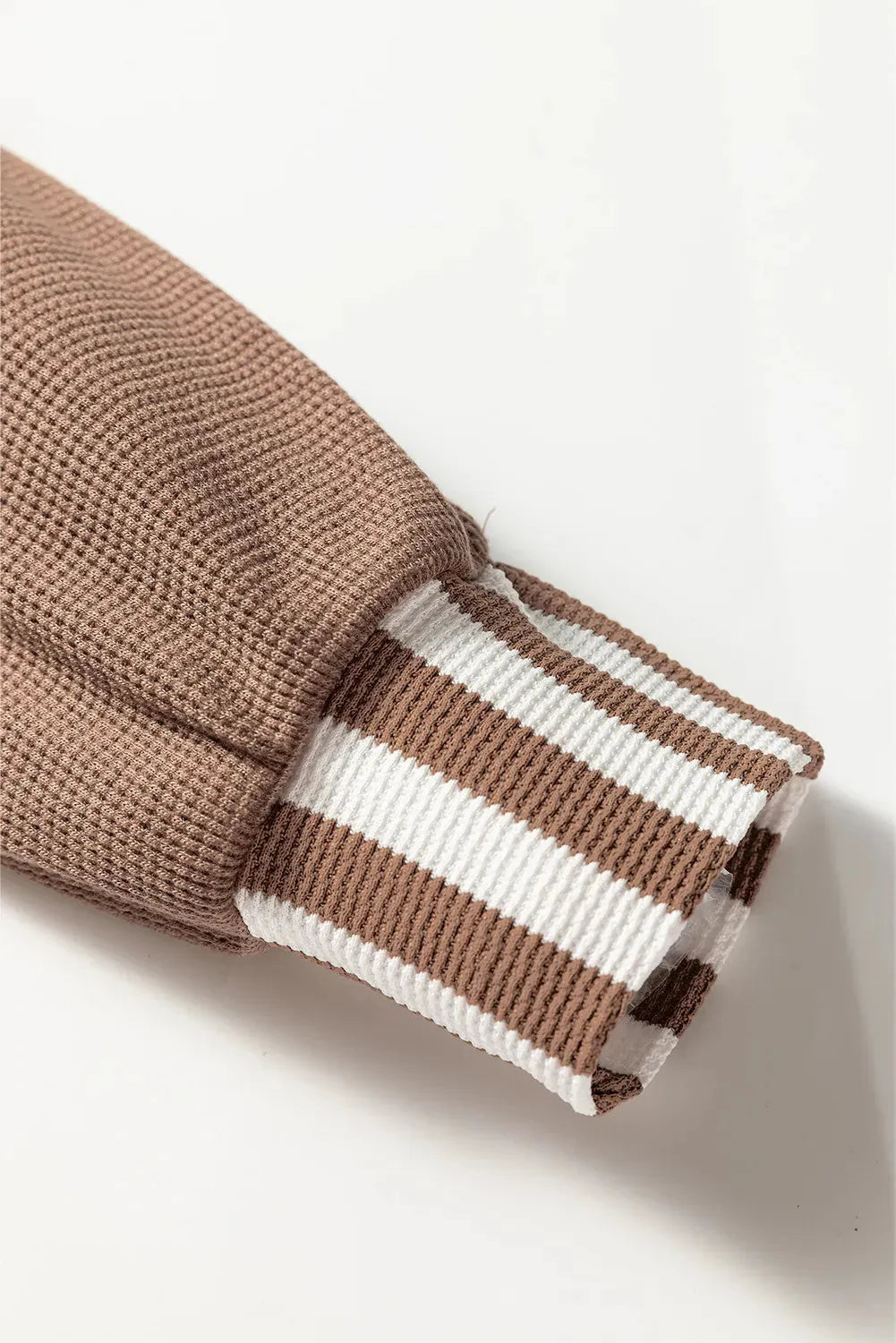 Straw yellow striped hoodie with waffle texture patchwork, button neck, and drawstring hood laid flat.