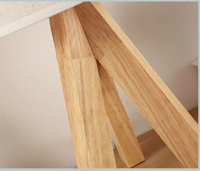 Solid wood LED table lamp with fabric shade in linen trumpet colour on wooden bedside table