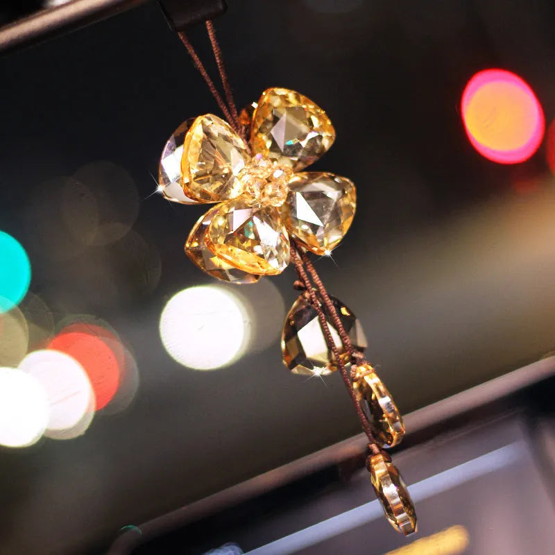 Crystal four leaf grass car pendant hanging, shown in different colour options including transparent and champagne.