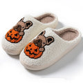 Black and white Halloween slippers with pumpkin pattern, plush upper, and textured rubber sole.