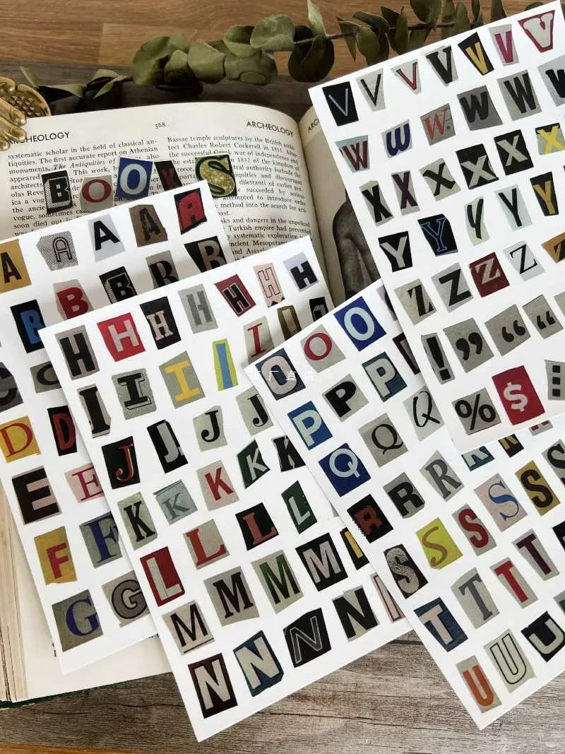 Pack of printed decorative stickers showing English letters, numbers, symbols, and weekly words in a cute style.