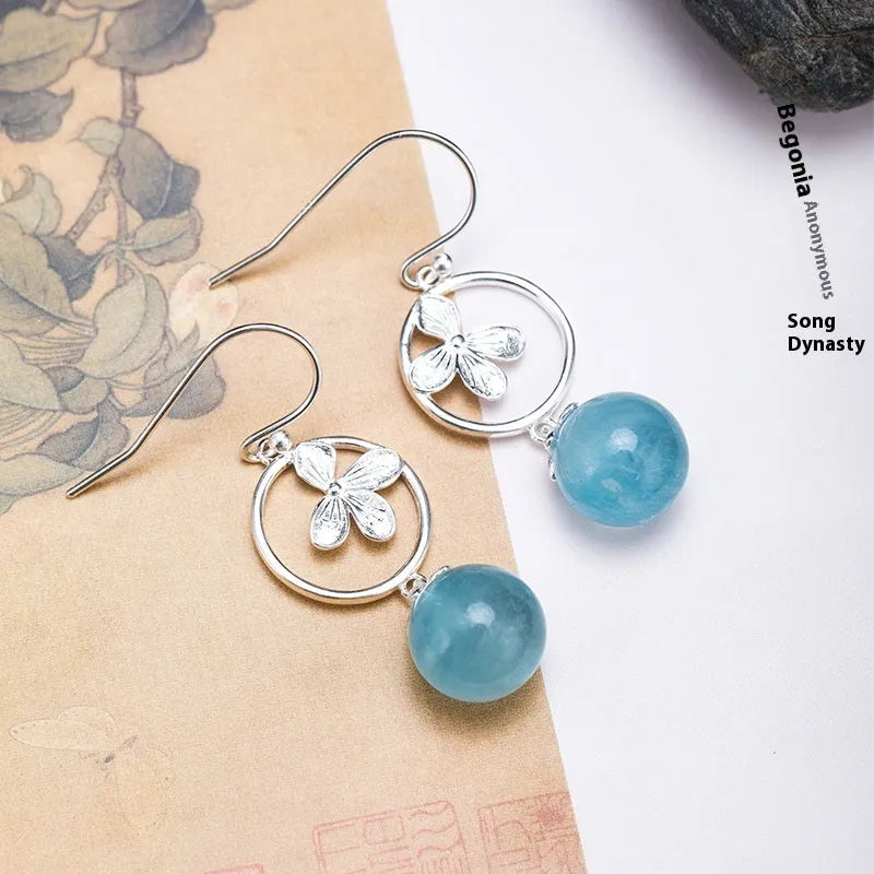 A pair of vintage-style silver earrings featuring aquamarine leaf and four-petal flower designs.