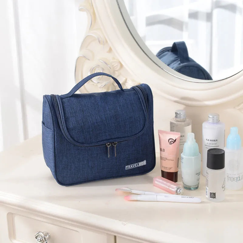 Cube-shaped cationic toiletry bag in black, folded open to show interior storage space