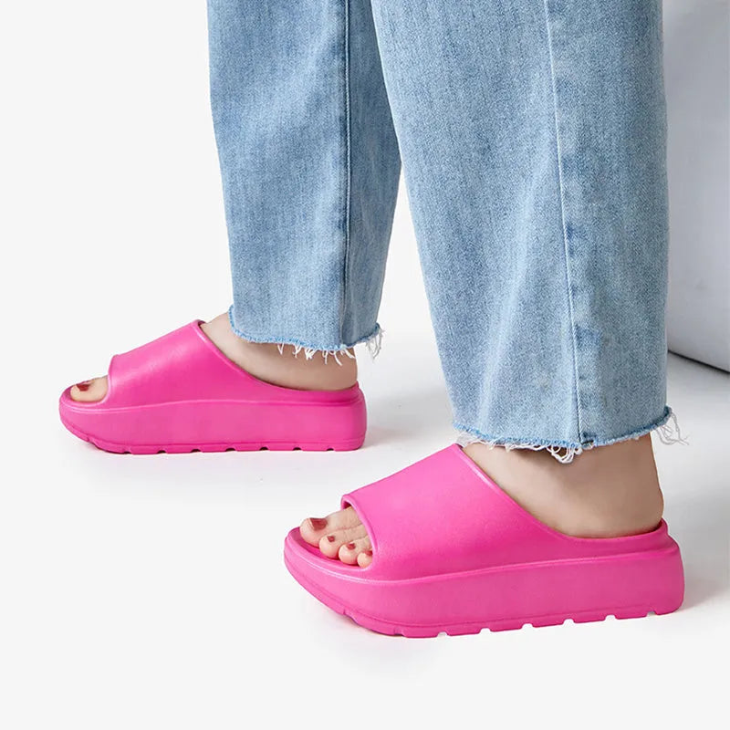 Women's beige fish mouth slippers with a thick light-coloured sole on a wooden floor.