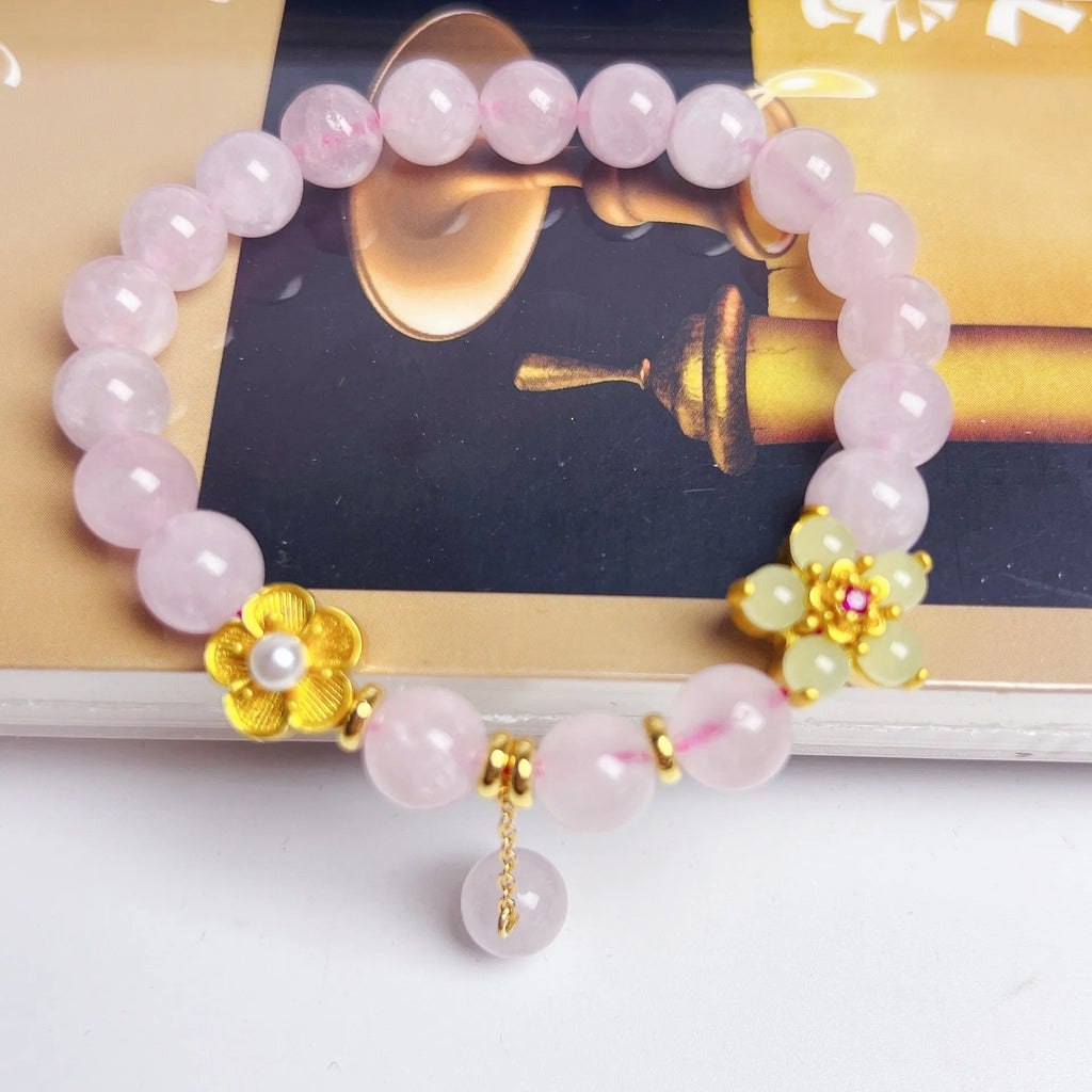 Close-up of a handmade pink crystal peach blossom bracelet on a wrist, showing adjustable closure.