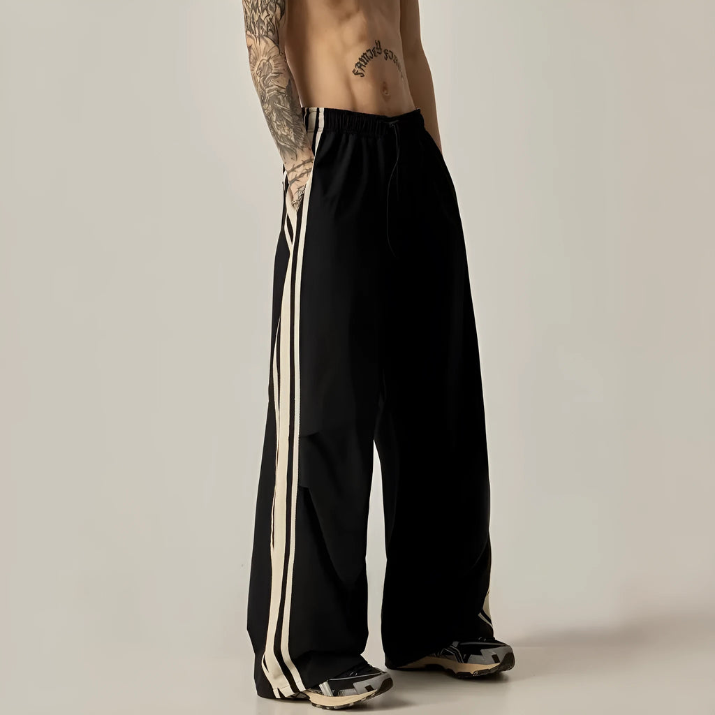 Black men's high-waist wide-leg climbing trousers laid flat, showing straight-leg design.