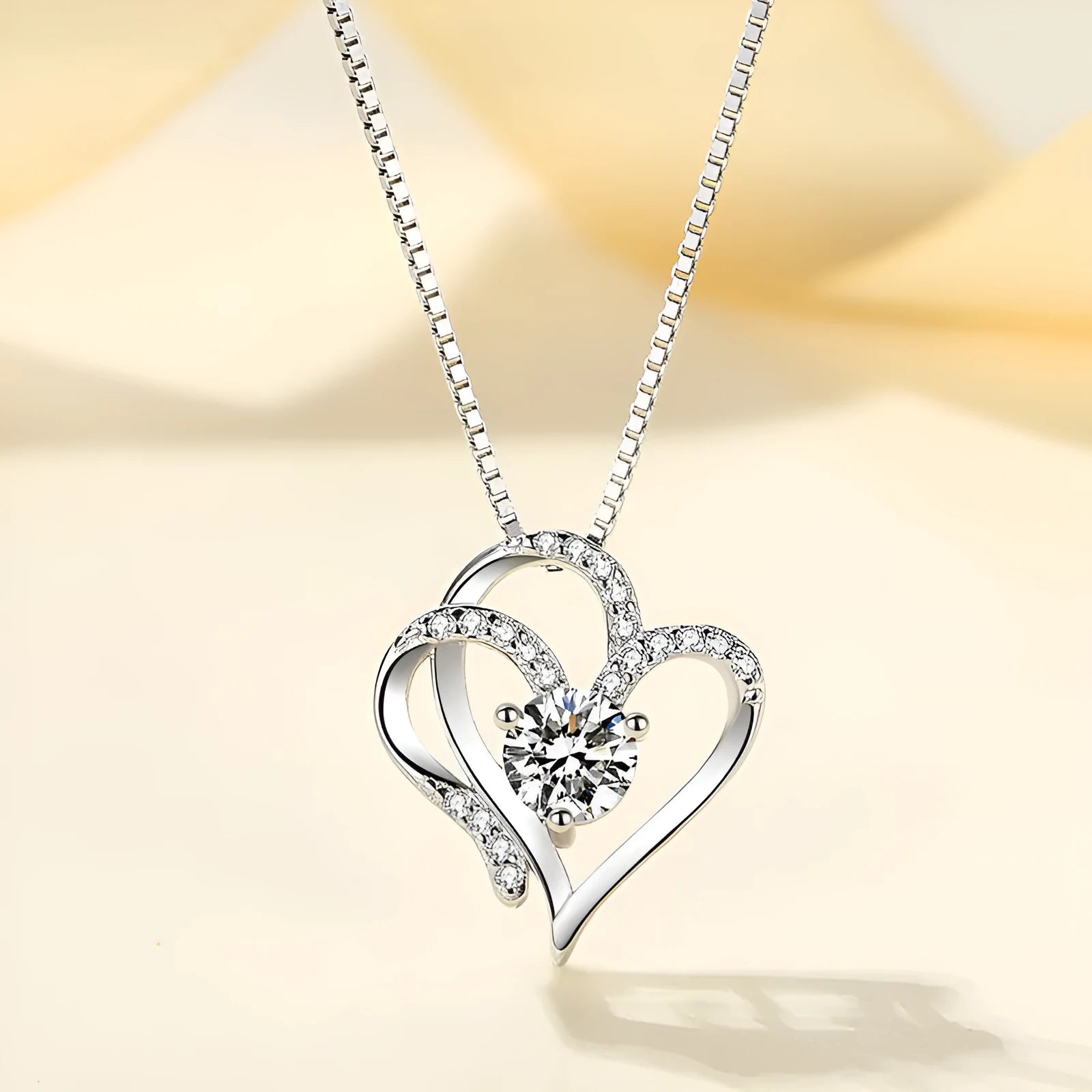 Women's heart-shaped 925 silver necklace with diamond-cut treatment on a model.
