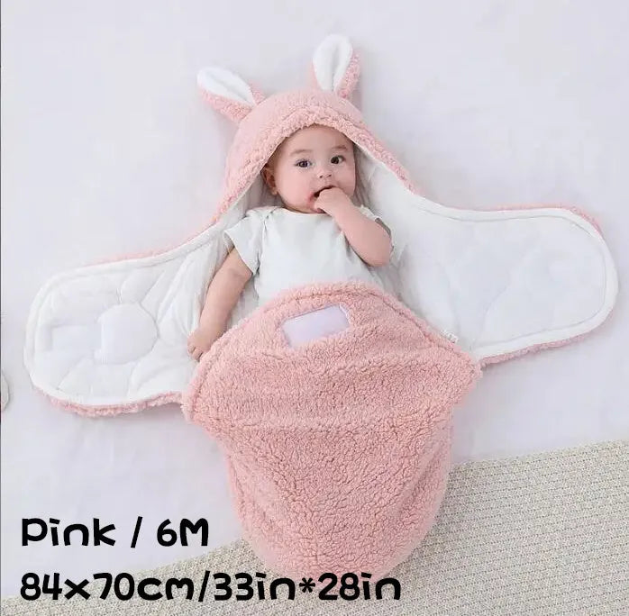 Baby wearing a grey adjustable fleece swaddle sleep sack with velcro wings
