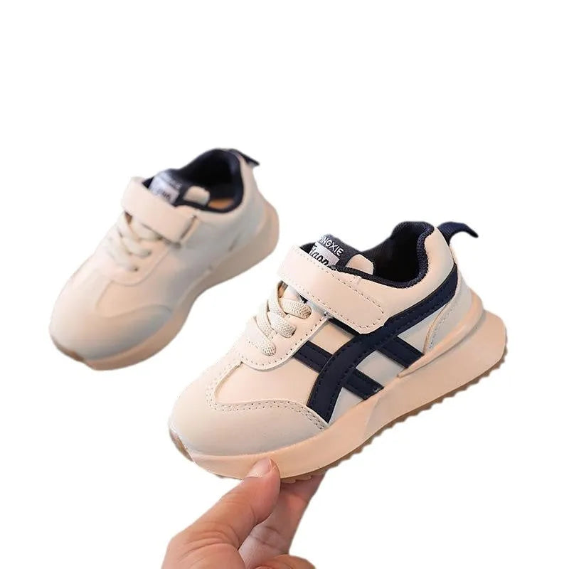 Children's solid-colour Velcro sneakers in synthetic leather with rubber soles, shown in beige.