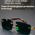 Frameless dark green crystal sunglasses with a minimalist design on a case, showcasing the tinted single-lens construction.