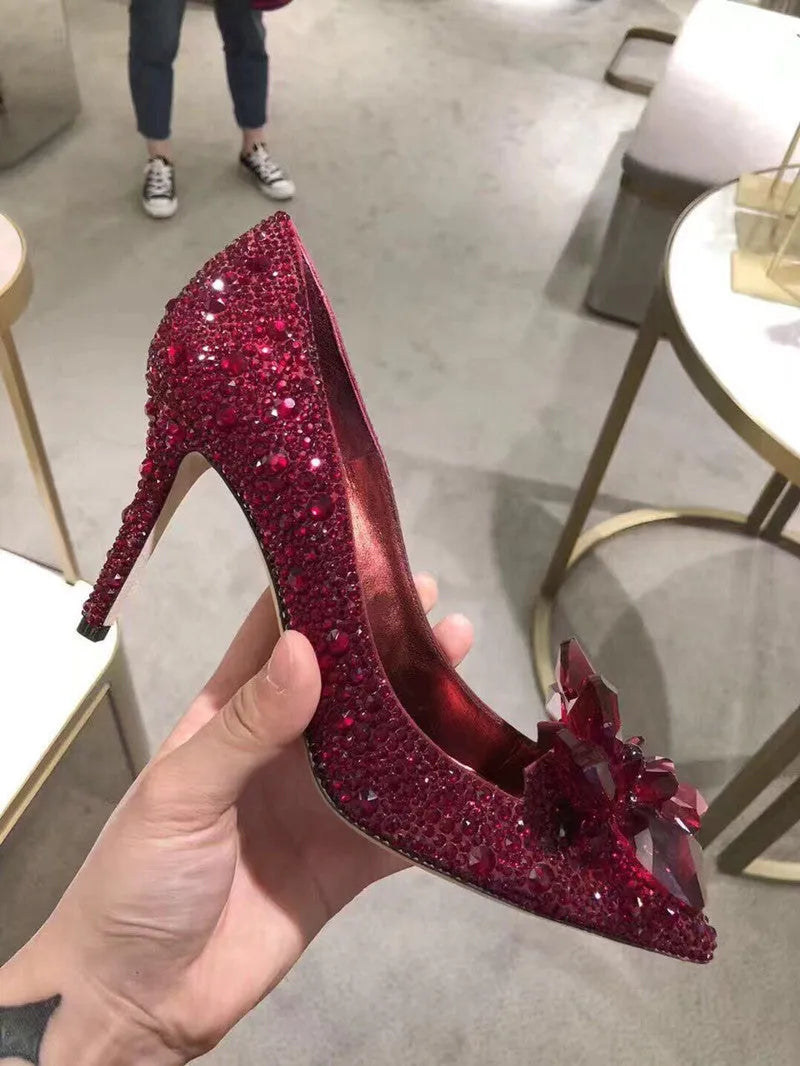 Women's gold high heels with pointed toe, rhinestone decoration, and a stiletto heel.