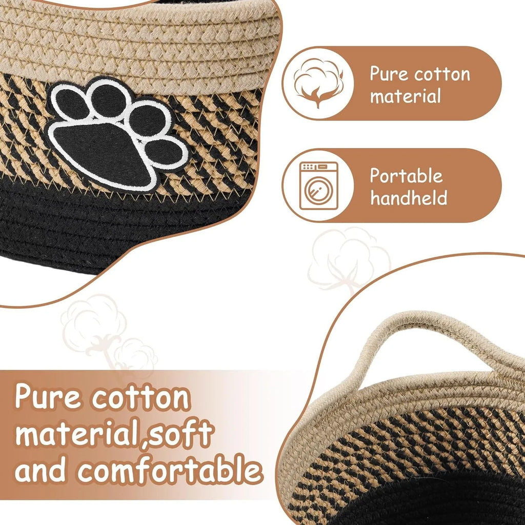 Handwoven light beige cotton rope storage basket with a wooden handle on a table.