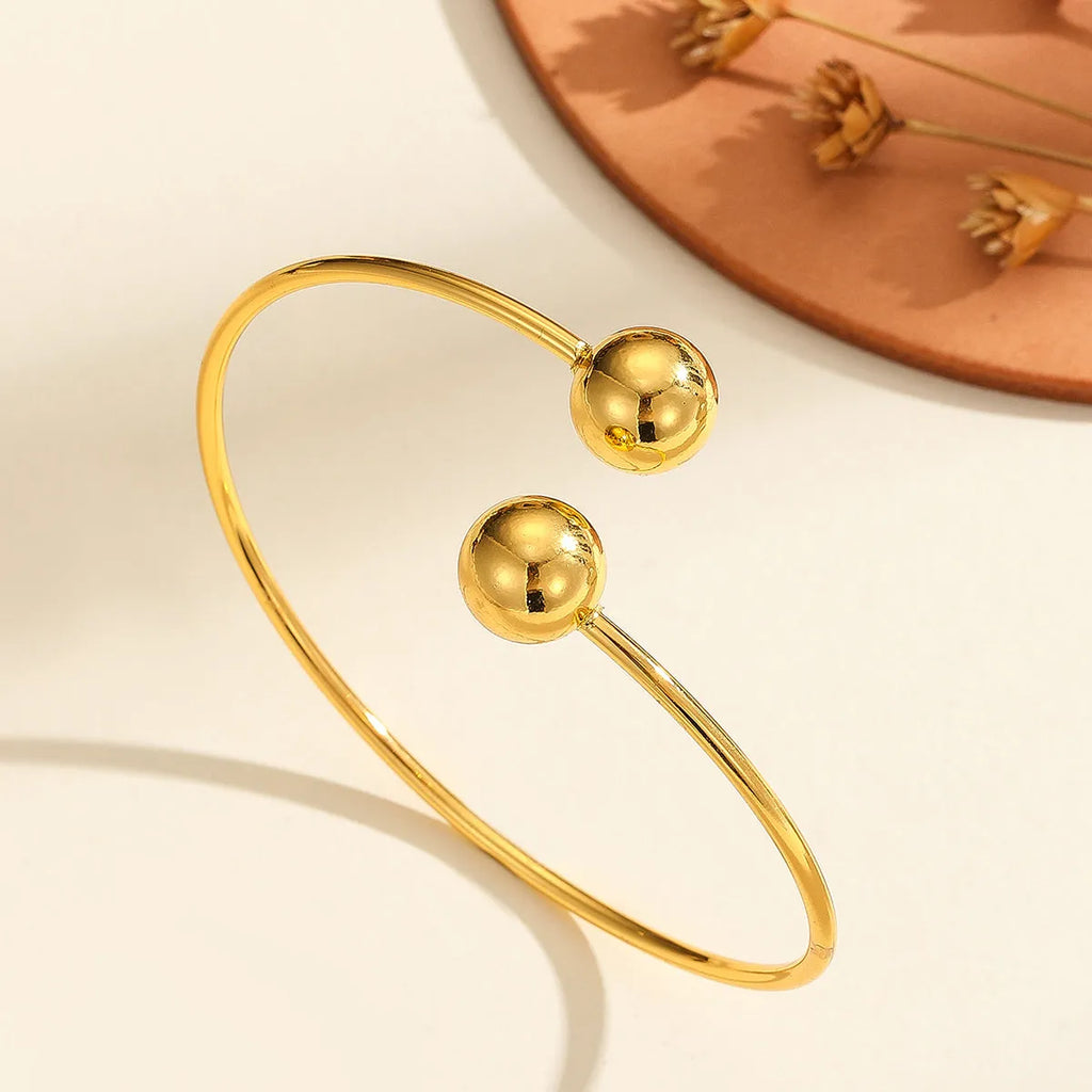 Golden copper plated 18k gold double bead opening bracelet on white background