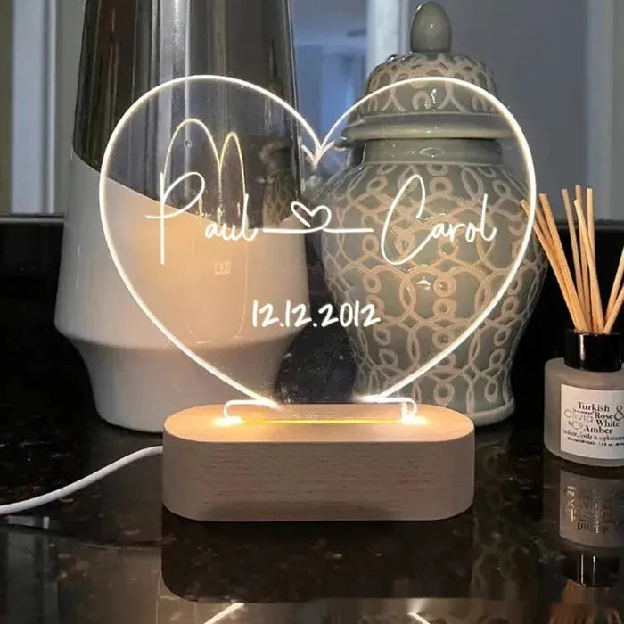 Custom engraved acrylic night light with names and date, illuminated by an LED base.