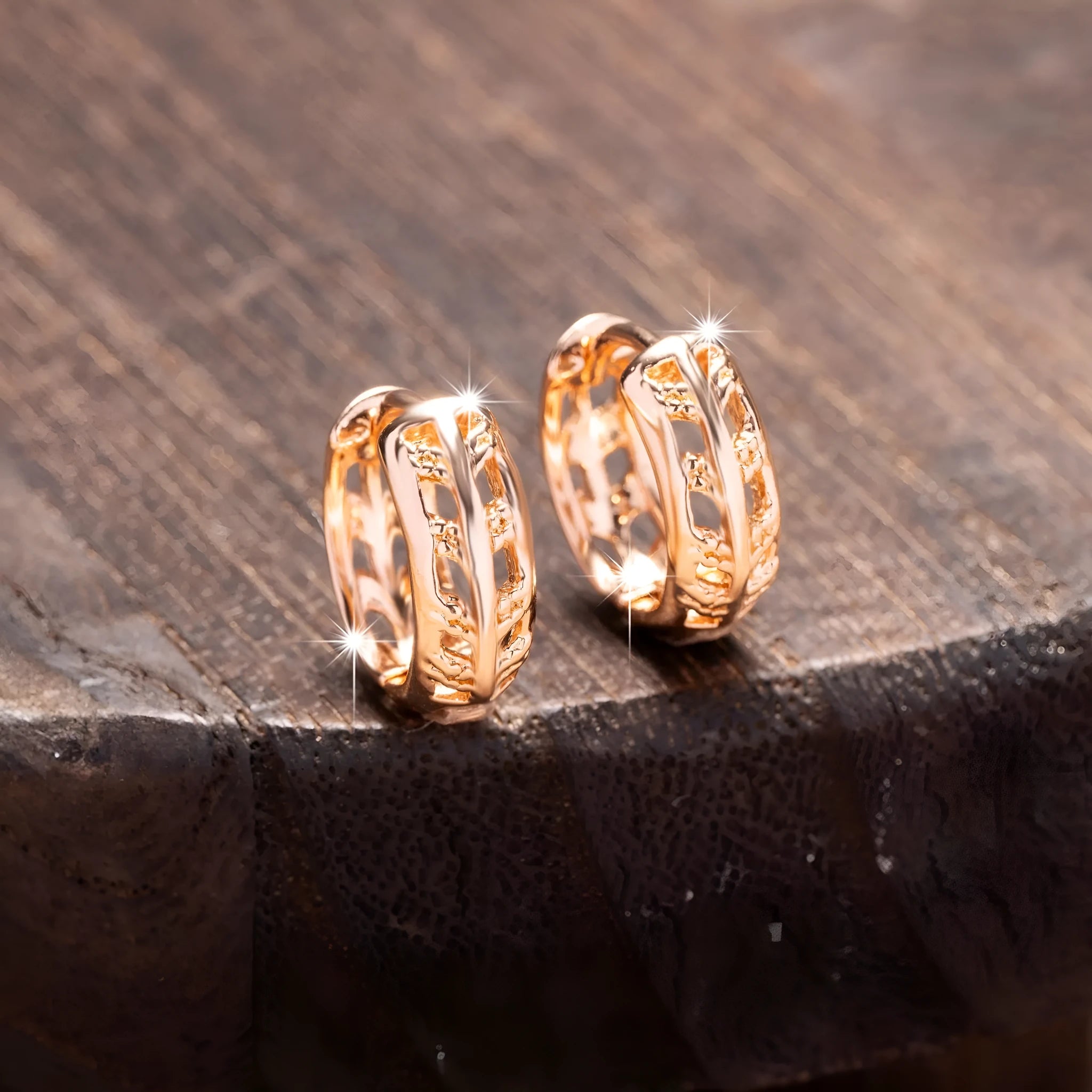 Rose gold hollowed-out heart and leaf shaped copper earrings on a white background, showing intricate cut-out details.