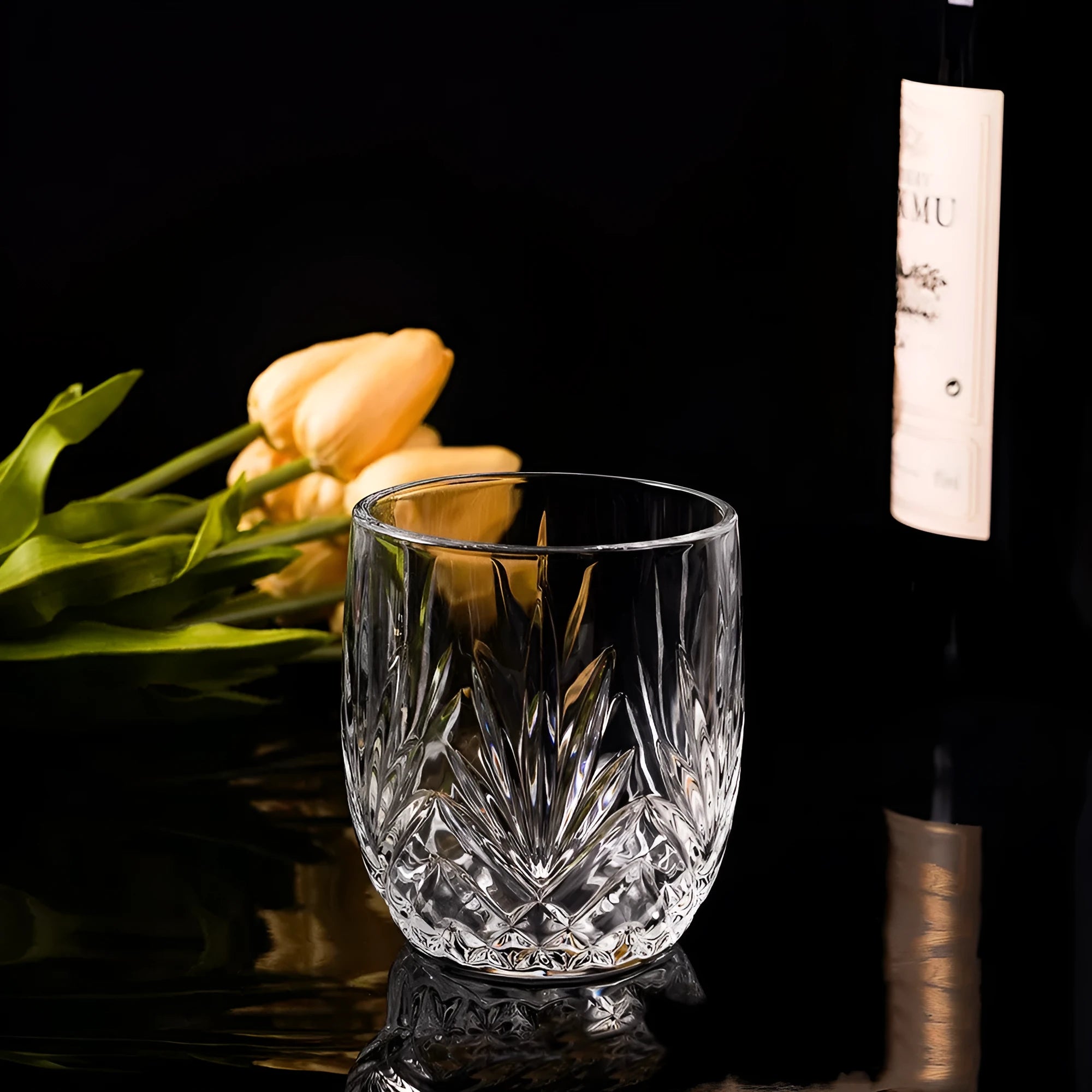 Thick-bottomed clear crystal whiskey shot glass on a table.