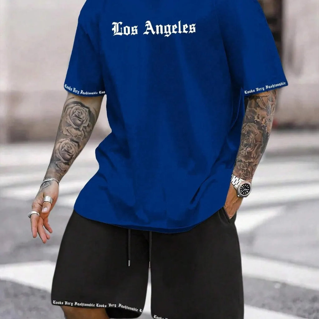 Man wearing a blue short-sleeved top and matching shorts from a sports style suit set.