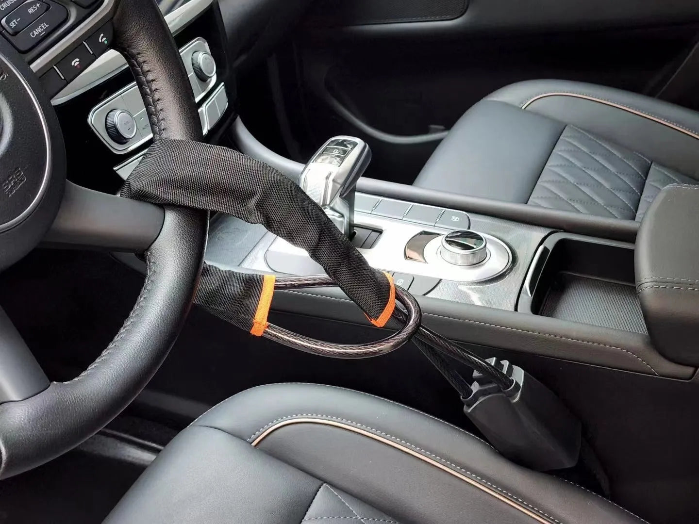 Red iron car steering wheel lock with brass core for General Motors vehicles on a steering wheel.