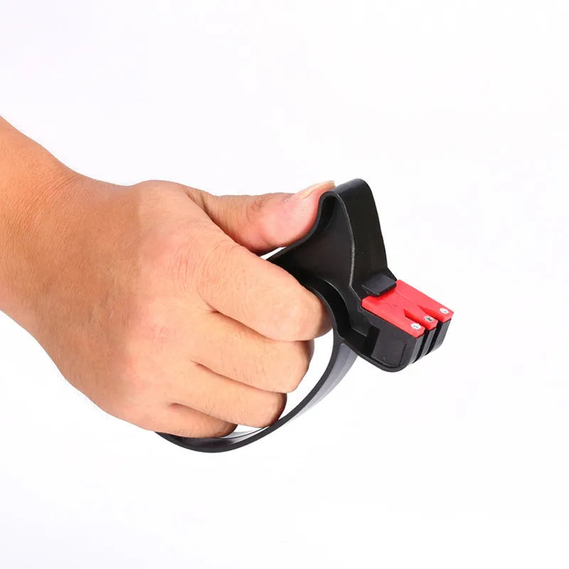 Black handheld knife and scissor sharpener with ergonomic handle on a plain background.