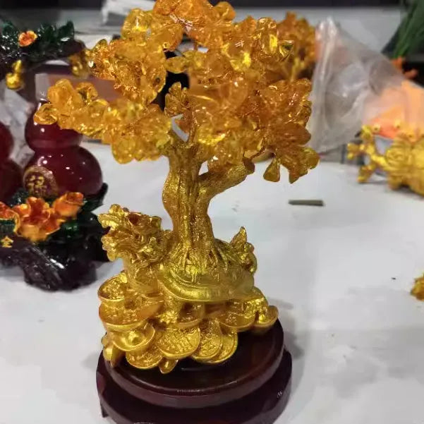 Citrine coloured small water turtle money tree resin ornament on a white background.