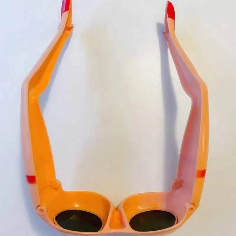 Orange novelty sunglasses with a sculptural leg and hip design on a white background.
