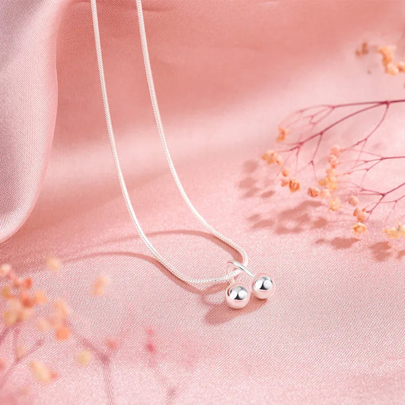Silver cherry pendant necklace on an adjustable snake bone chain for women.