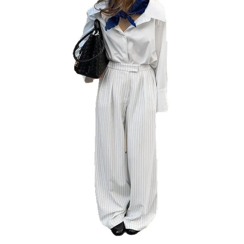 White striped wide-leg women's trousers with a front zip on a hanger.
