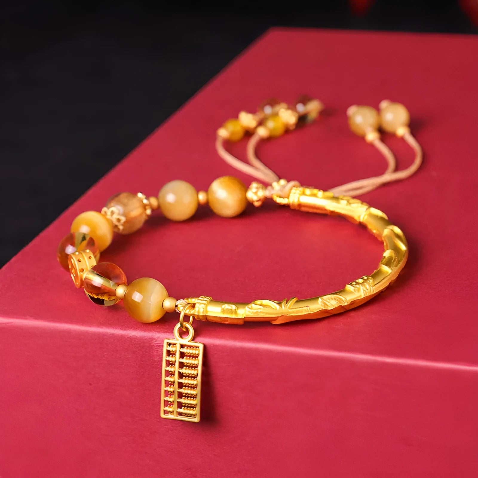 Close-up of a women's beaded bracelet with diamond-shaped tigereye and citrine stones and copper details.