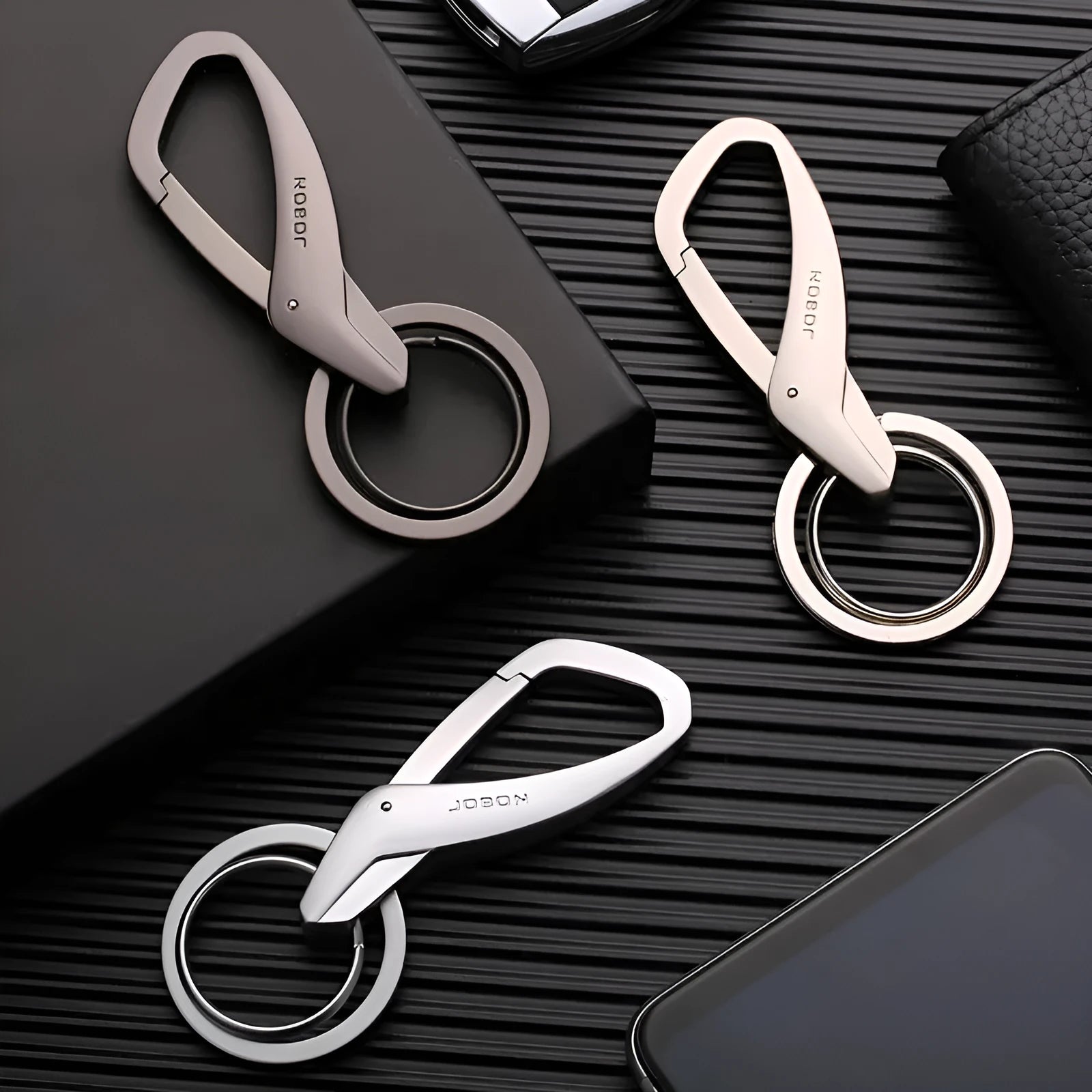 Black zinc alloy double ring key chain on a table, showing its 8.3cm length and compact design.