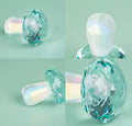 Colourful mushroom-shaped crystal decoration in geometric style on a surface, showing light green hue.